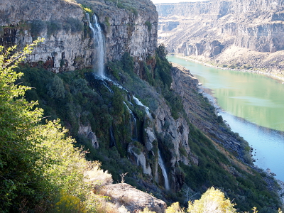 [A multi-drop waterfall comes over the canyon wall and down several hundred feet in multiple drops to the Snake River.]